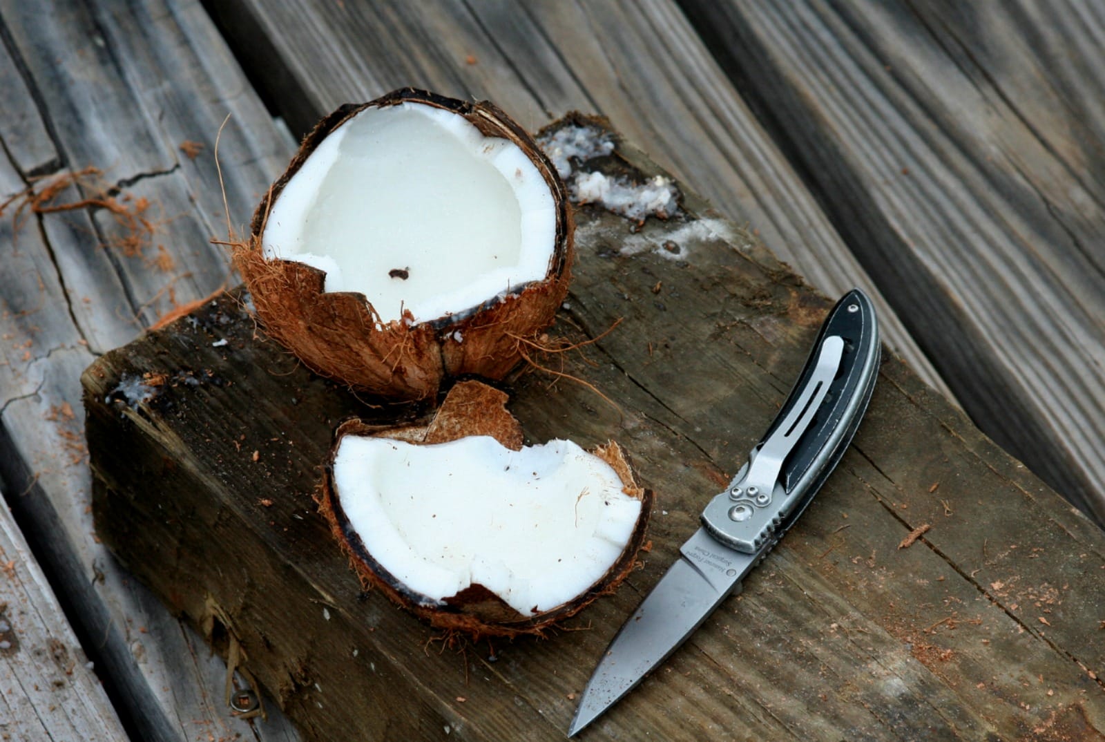 A cut open coconut on a cutting board