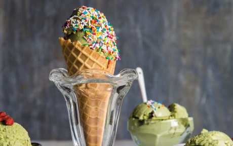 vegan coconut Matcha green tea ice cream in a cone with sprinkles