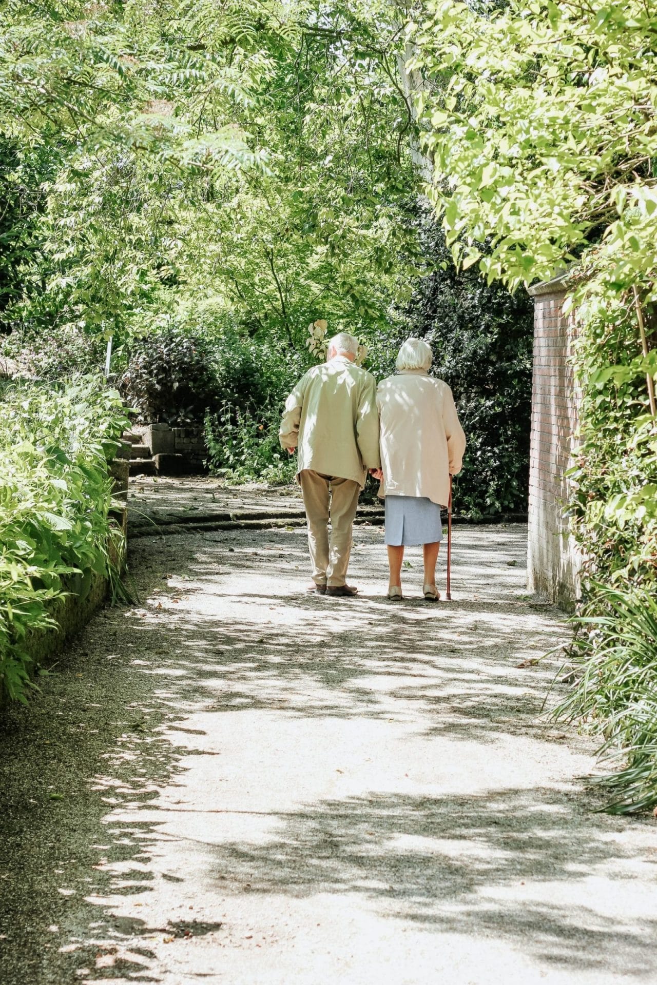 elderly couple walking together in park