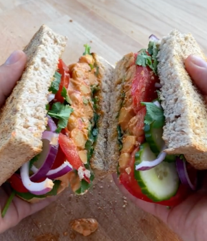 someone holding open a vegan sandwich