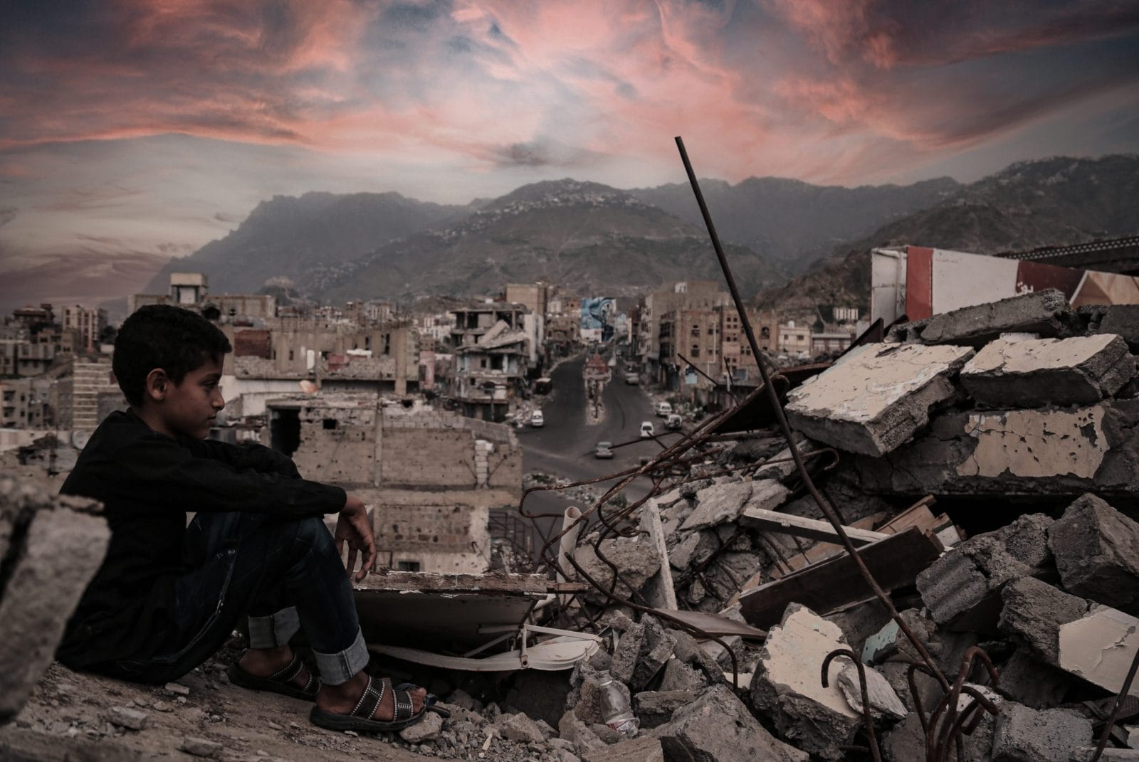 Child in Yemen looking out over destroyed city