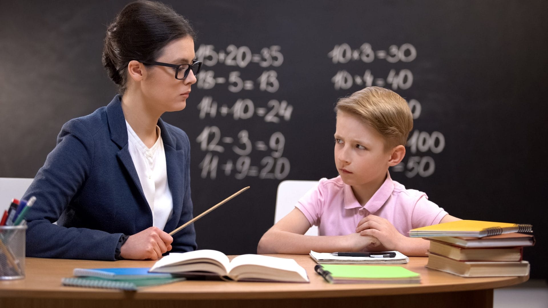 Schoolboy looking cautiously at teacher