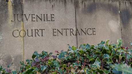 Weathered stone slab sign with the words Juvenile Court Entrance
