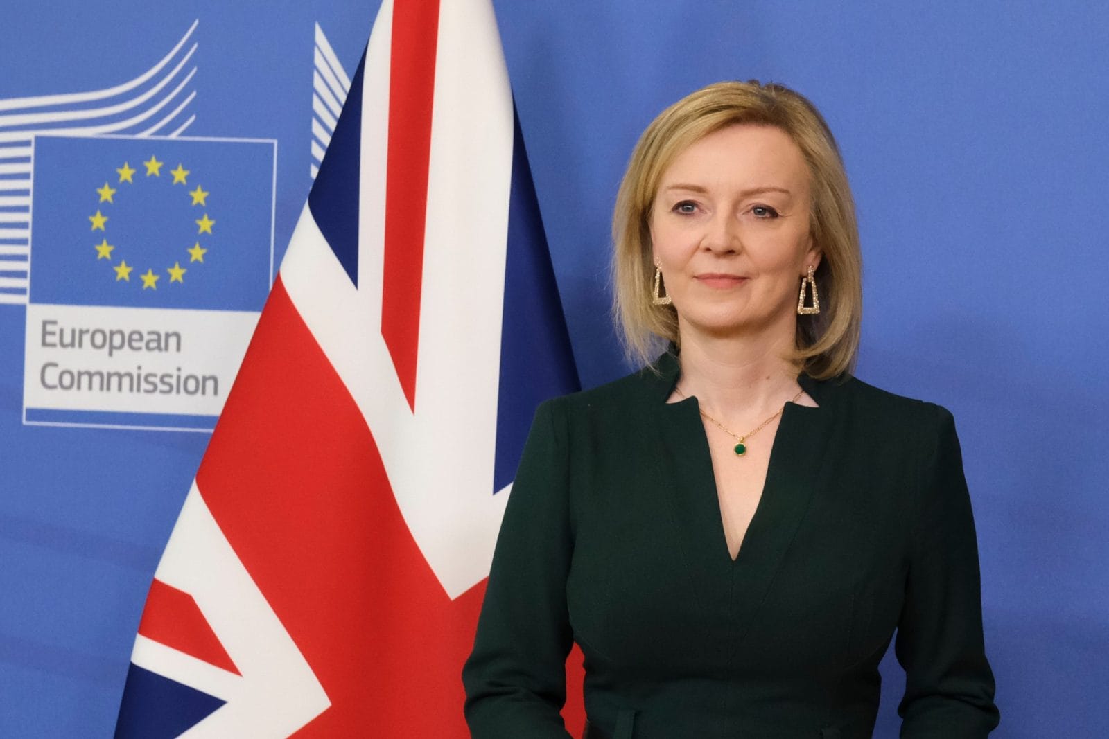 Liz Truss in front of a flag