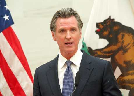 Gavin Newsom in front of California and American flag